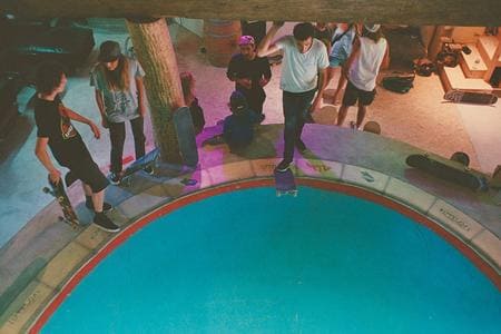 Skateurs autour d'une piscine vide pour une session.