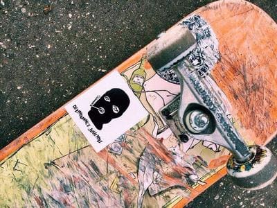 Skateboard usé avec autocollant et dessins artistiques
