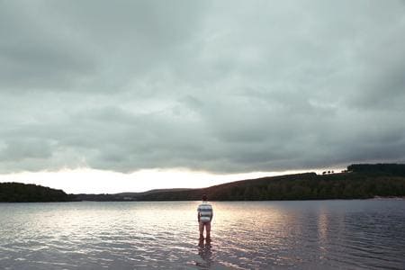 Personne debout dans un lac au coucher du soleil
