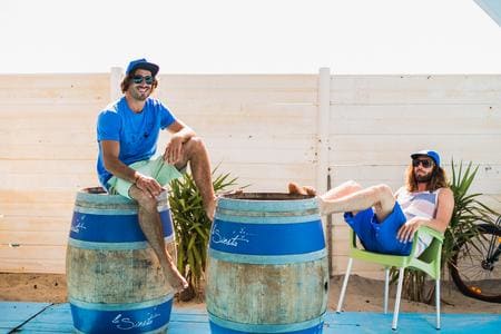 Hommes détendant sur tonneaux près de la plage