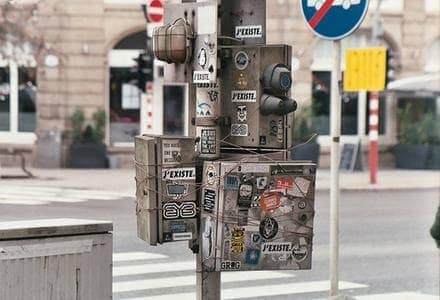 Poteau urbain couvert d'autocollants et de graffitis