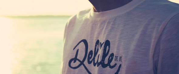 Homme en t-shirt à la plage au coucher du soleil