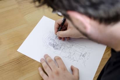 Personne dessinant un croquis sur une feuille de papier