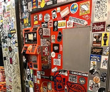 Porte urbaine recouverte d'autocollants colorés et de graffitis