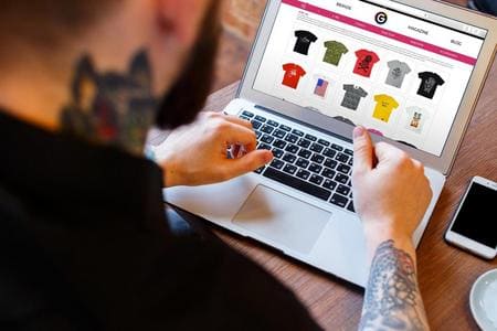 Homme tatoué achetant des T-shirts en ligne