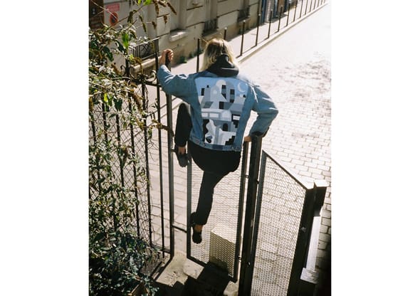 Personne de dos escaladant une rampe avec une veste designée par Ivan 14