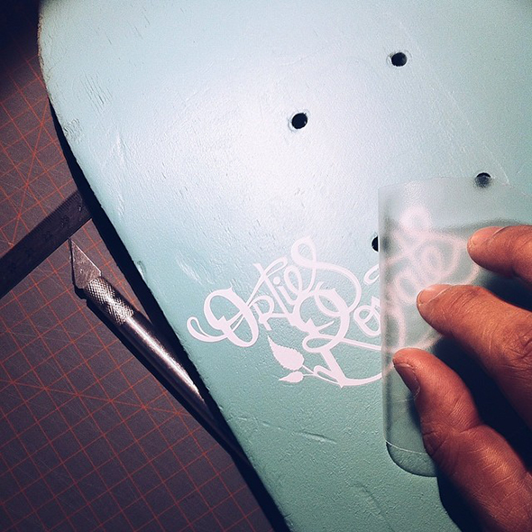 collae d'un logo et lettrage découpé dans du vinyle adhésif blanc avec papier transfert 'tape'