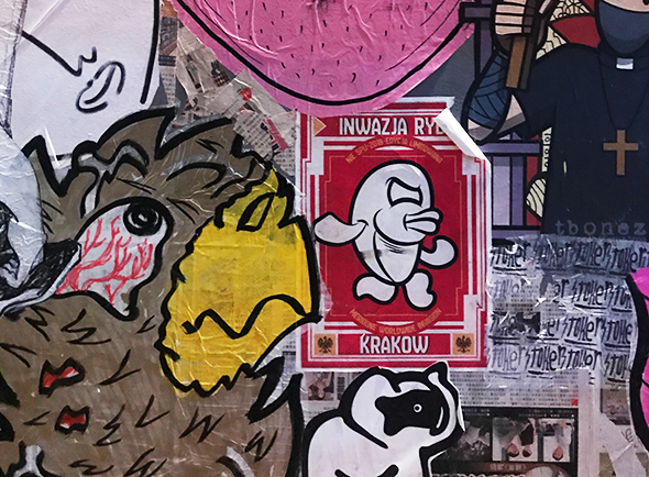 Plusieurs stickers collés sur un mur en extérieur dont un stickers Merione, célèbre colleur de stickers en provennce de Rome en Italie