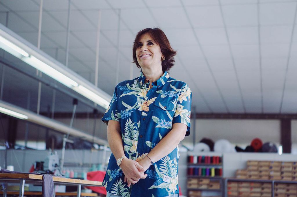 Employée souriante dans un atelier de conception de vêtements personnalisés