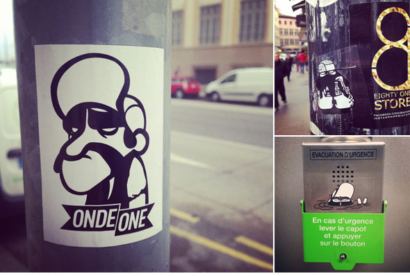 Collage de différents stickers personnalisés par Onde One et imprimés en sérigraphie noir sur vinyle adhésif blanc par High Stickers et collés dans un environnement urbain