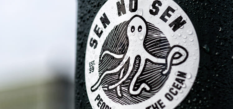 stickers personnalisé imprimé en sérigraphie noir et blanc collé sur un poteau, autocollant étanche